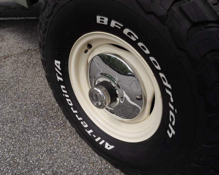 Cream Bronco wheel with a vintage Ford hubcap and 33-inch BFGoodrich tire